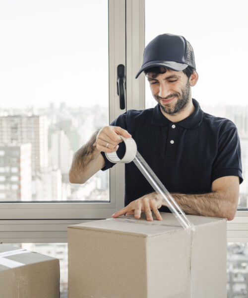 smiling-delivery-man-uniform-packing-cardboard-box