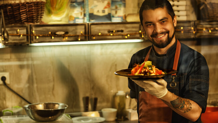 Smiling chef showing dish with tasty vegetable salad. Indian Chef Jobs in Europe